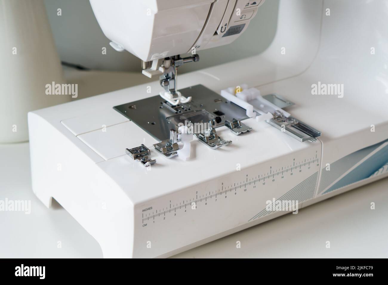 White modern ewing machine and its components close up. Sewing needle
