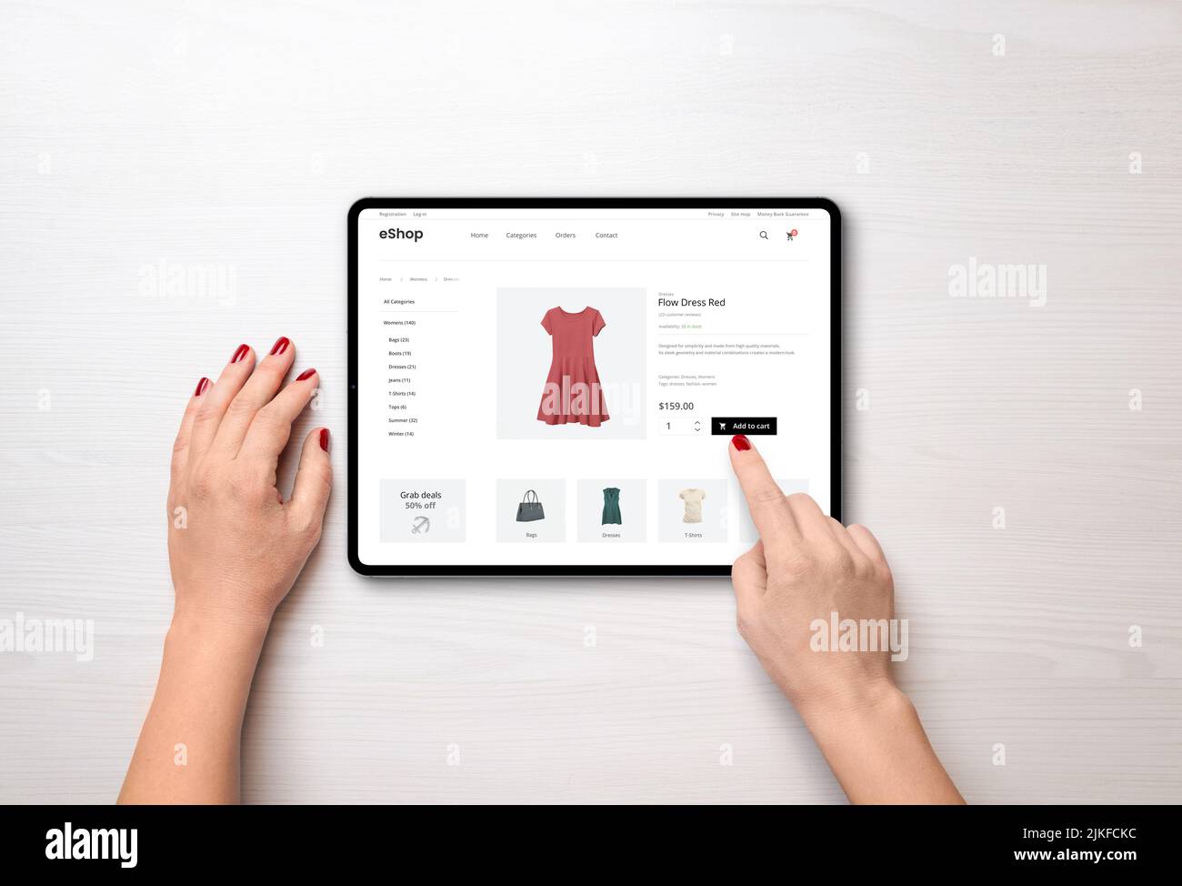 Online shopping with a tablet. Red women's dress on the e-commerce web page Stock Photo