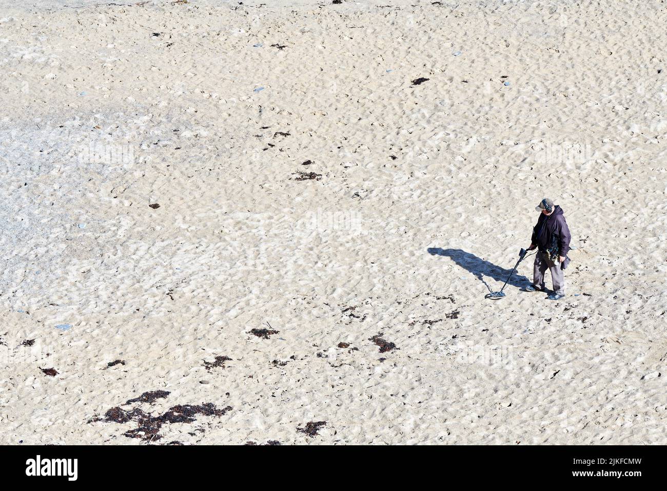 Treasure hunter with metal detector at the Tolcarne beach, Newquay