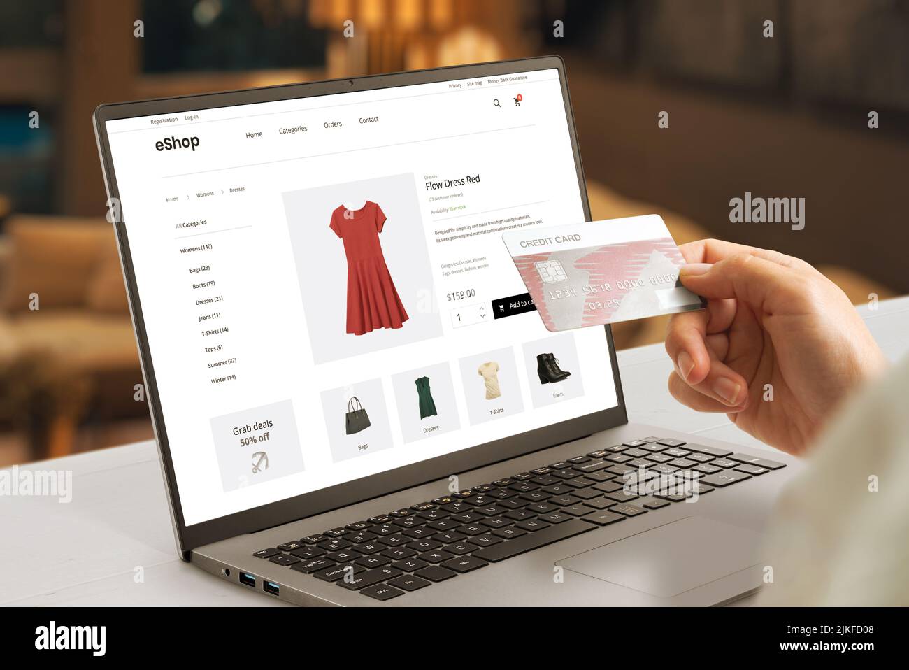 Shopping online with credit card concept. Modern e-commerce web page with woman clothes on laptop display Stock Photo
