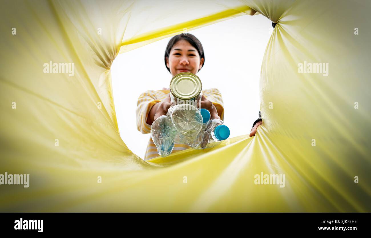 Woman throws Plastics trash garbage into a garbage. Woman putting trash