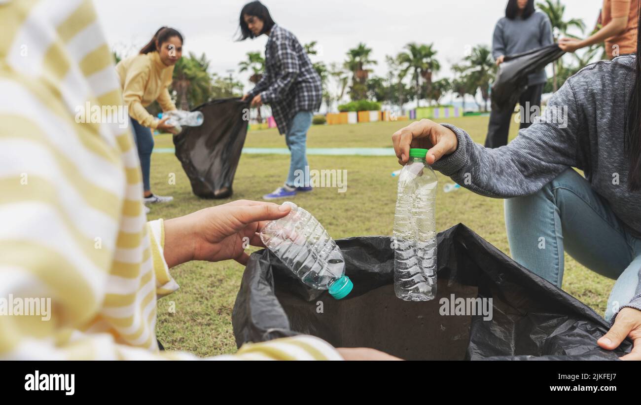 Asia Woman Group Team Volunteer picking up Trash plastics garbage
