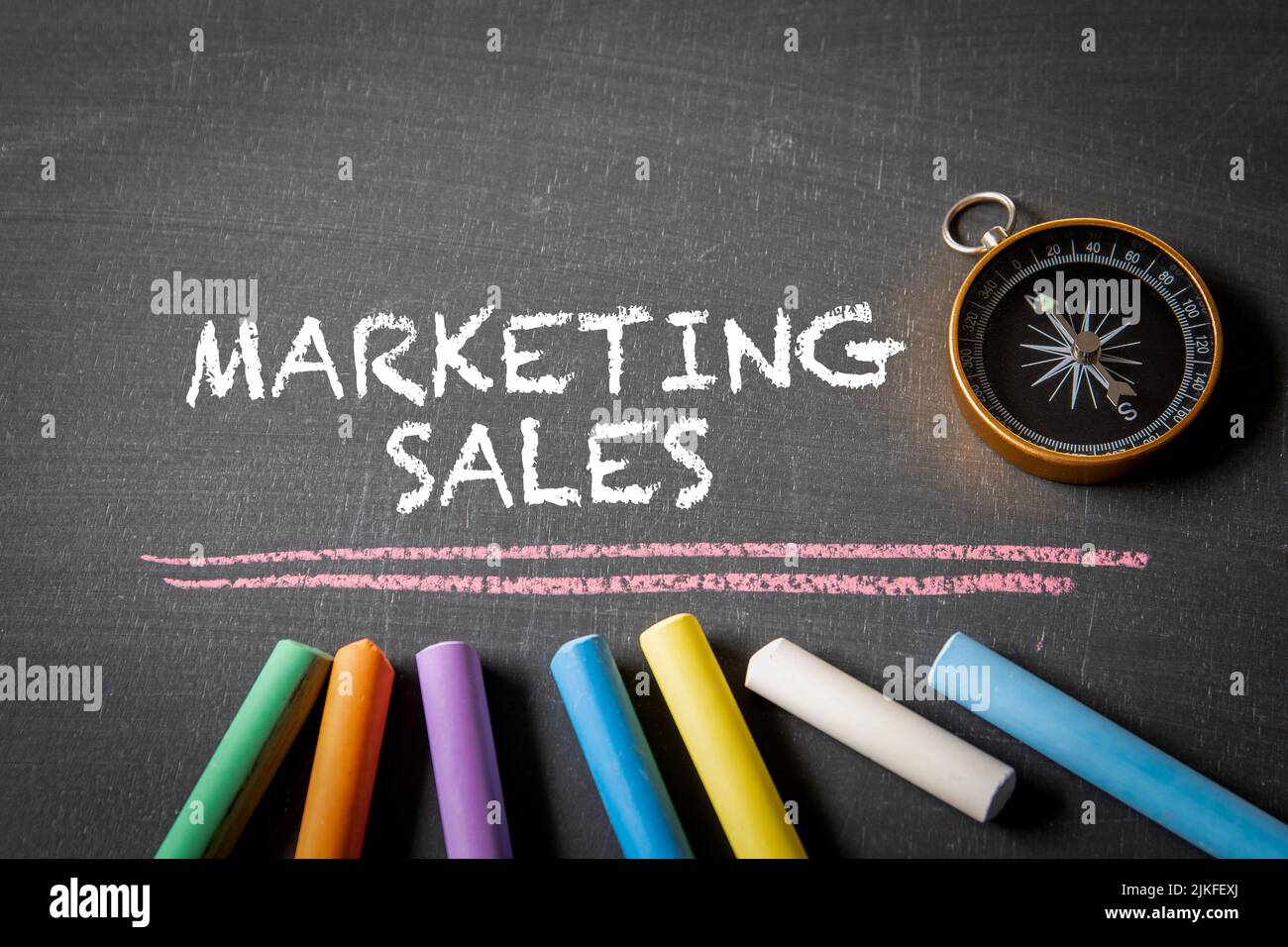 Marketing Sales. Compass and colored pieces of chalk on a blackboard. Stock Photo
