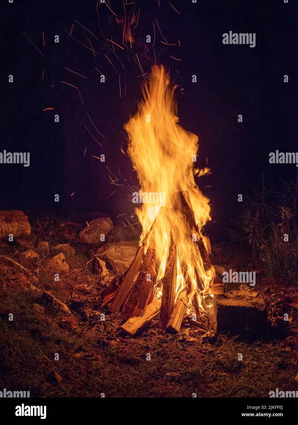 logs burning in camp fire in darkness Stock Photo