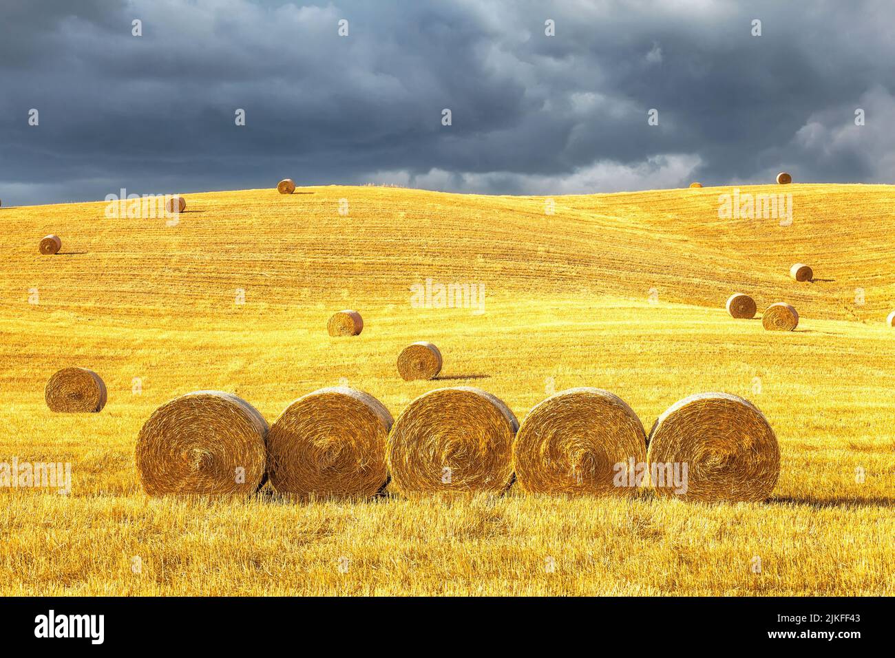 Hay bales on the field at sunset in Tuscany, Italy Stock Photo