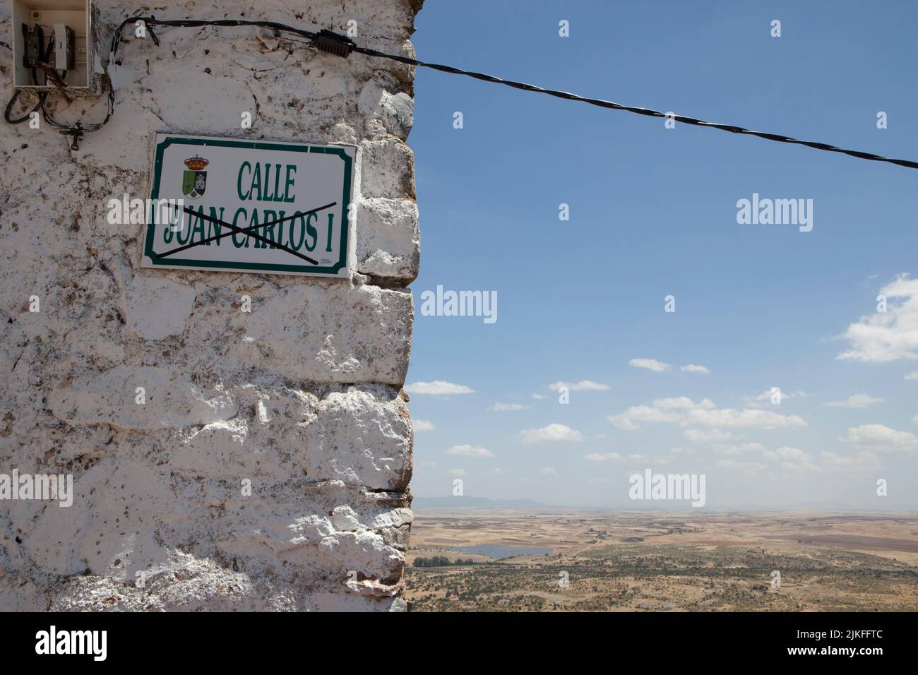 Magacela, Spain - July 3rd, 2022: Street plaque with the name of King Juan Carlos I crossed out. Mountain village background Stock Photo