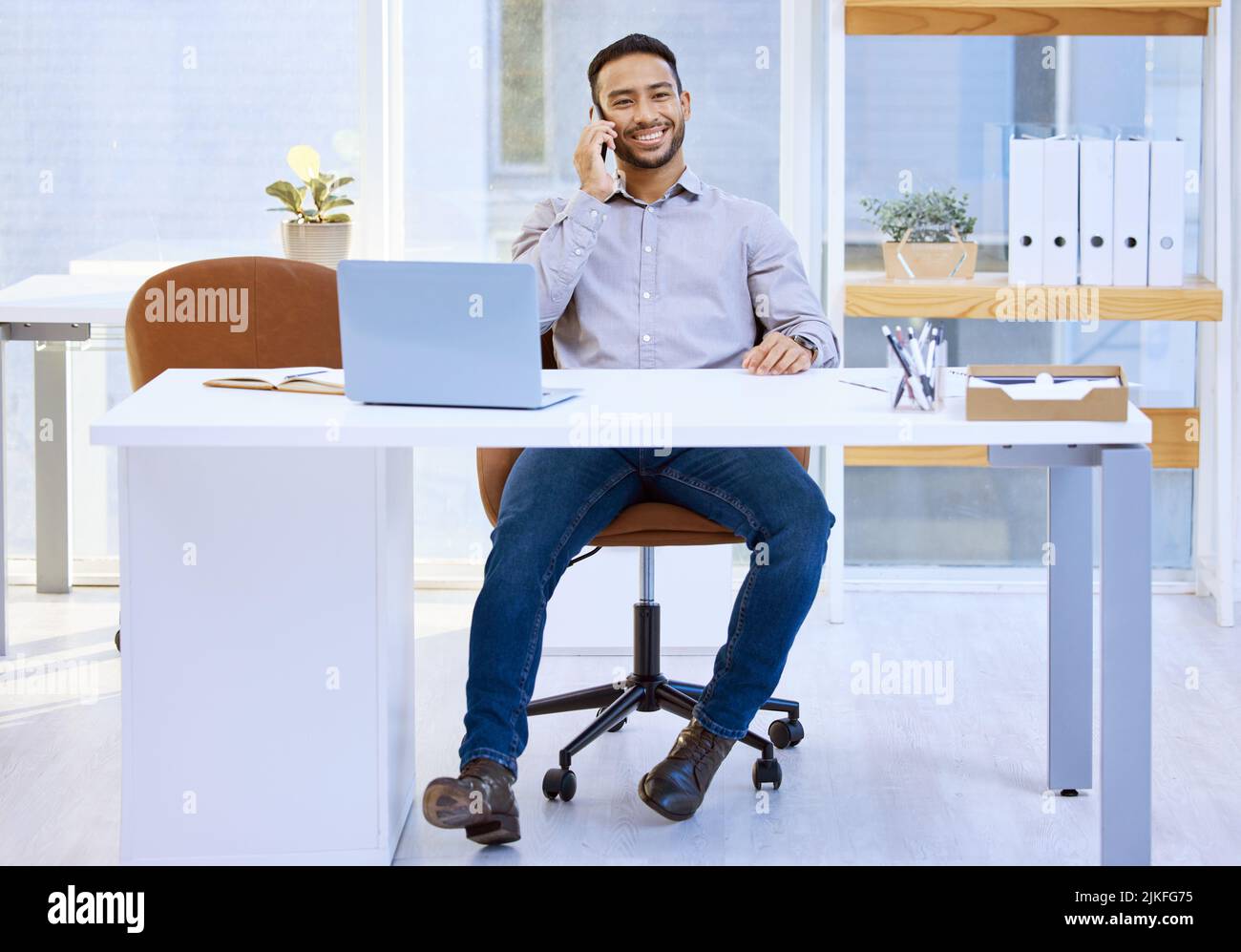 You dont wait for opportunities to come your way, you go scouting for it. a businessman talking on his cellphone while sitting at his desk. Stock Photo
