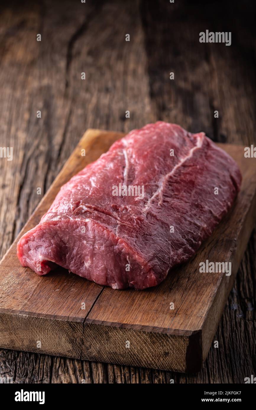 Raw rib eye steak whole on a wooden board. Stock Photo