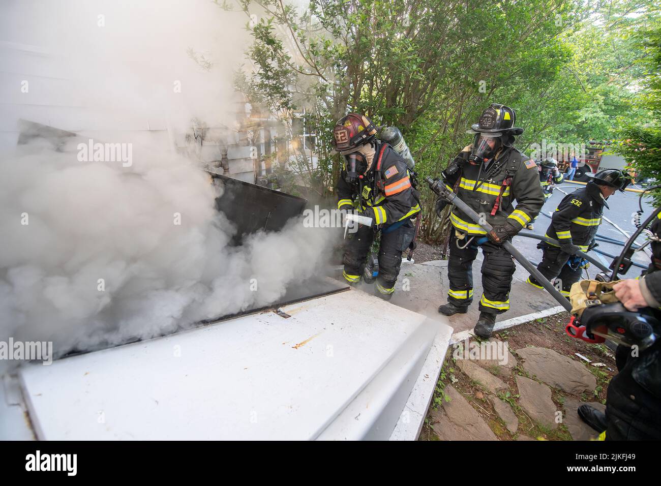 East Hampton firefighters prepare to enter the basement through a Bilco door as at 5:57 a.m. on Friday, May 14th, 2021, the East Hampton Fire Departme Stock Photo
