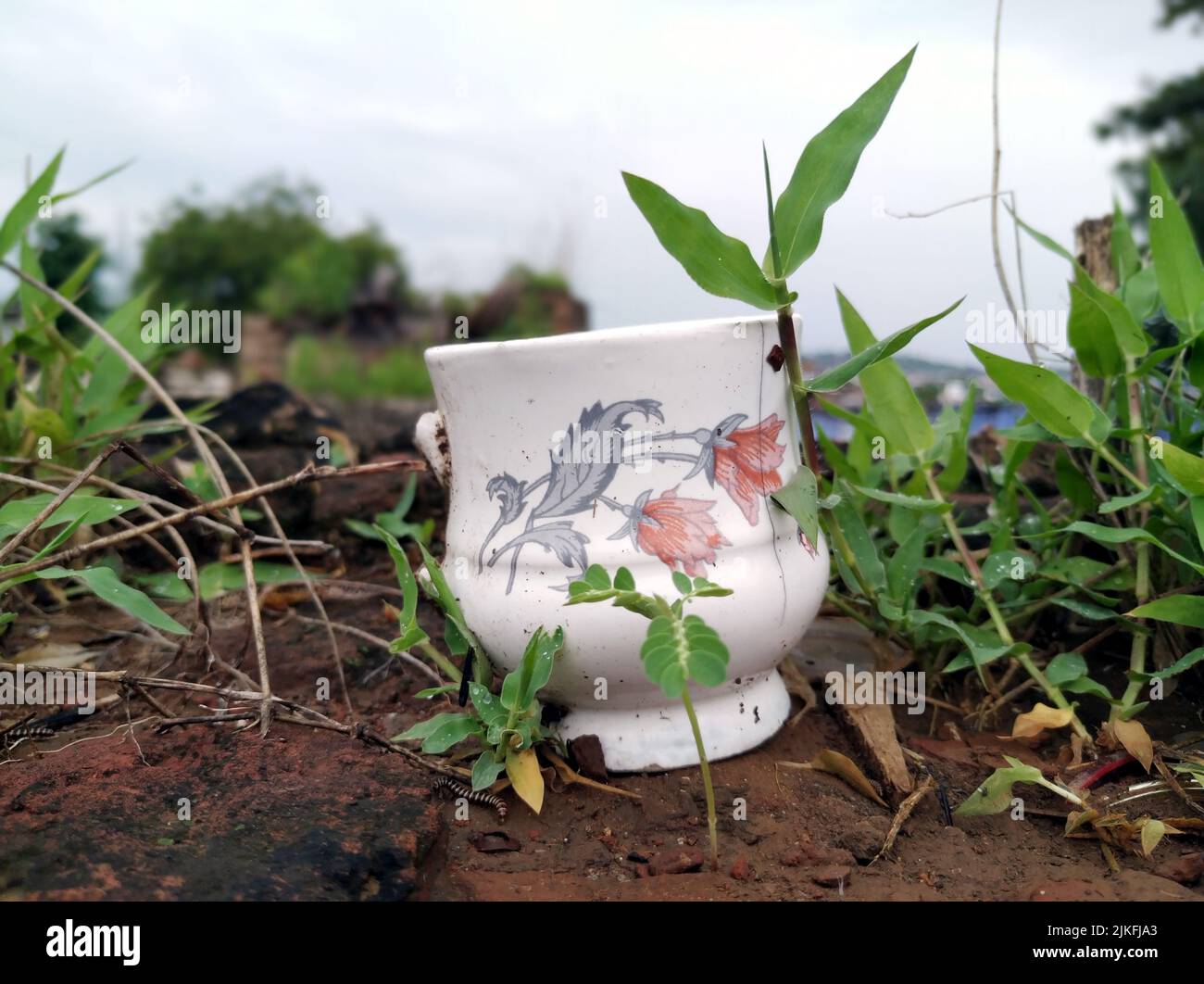 a broke mug put in dry mud Stock Photo