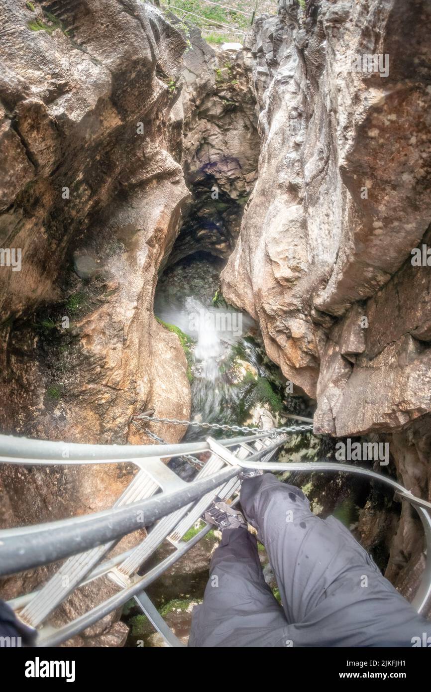 man descends the metal ladder towards the Trollkirka  - The Troll Church cave in Norway Stock Photo