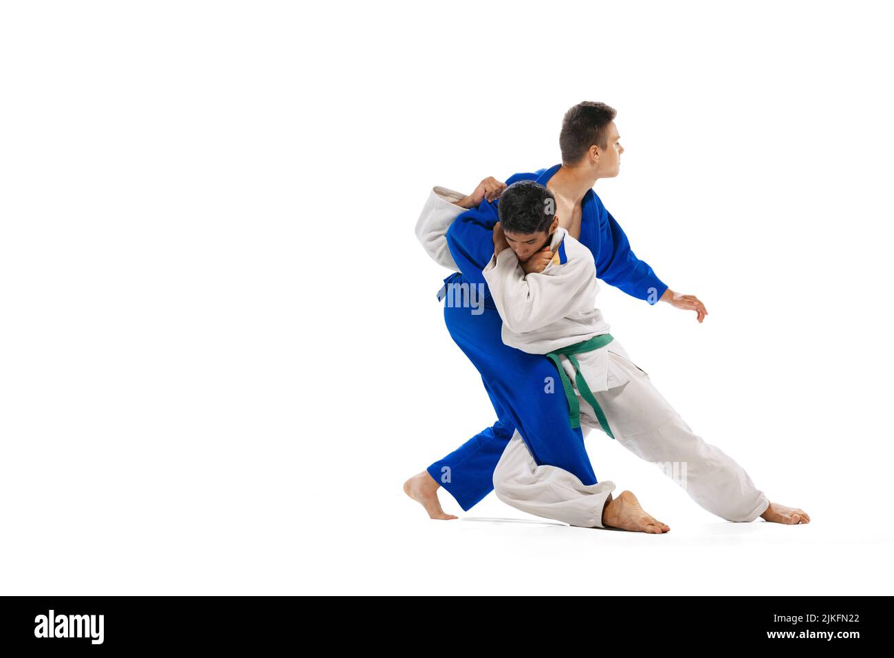 Studio shot of two men, professional judo athletes training isolated