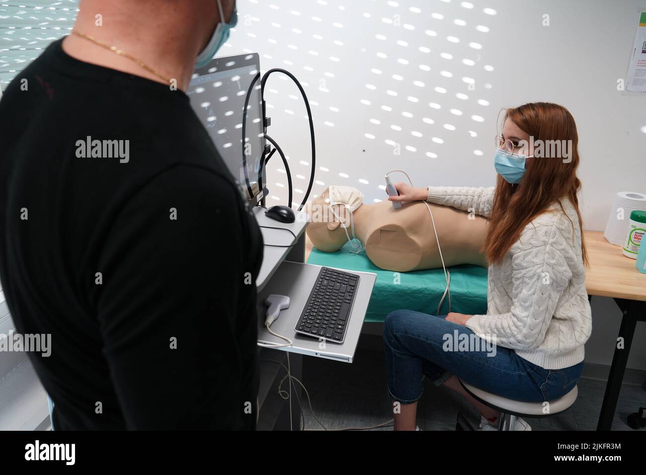 Students and their teacher during an echography simulation workshop on a robot mannequin. Stock Photo