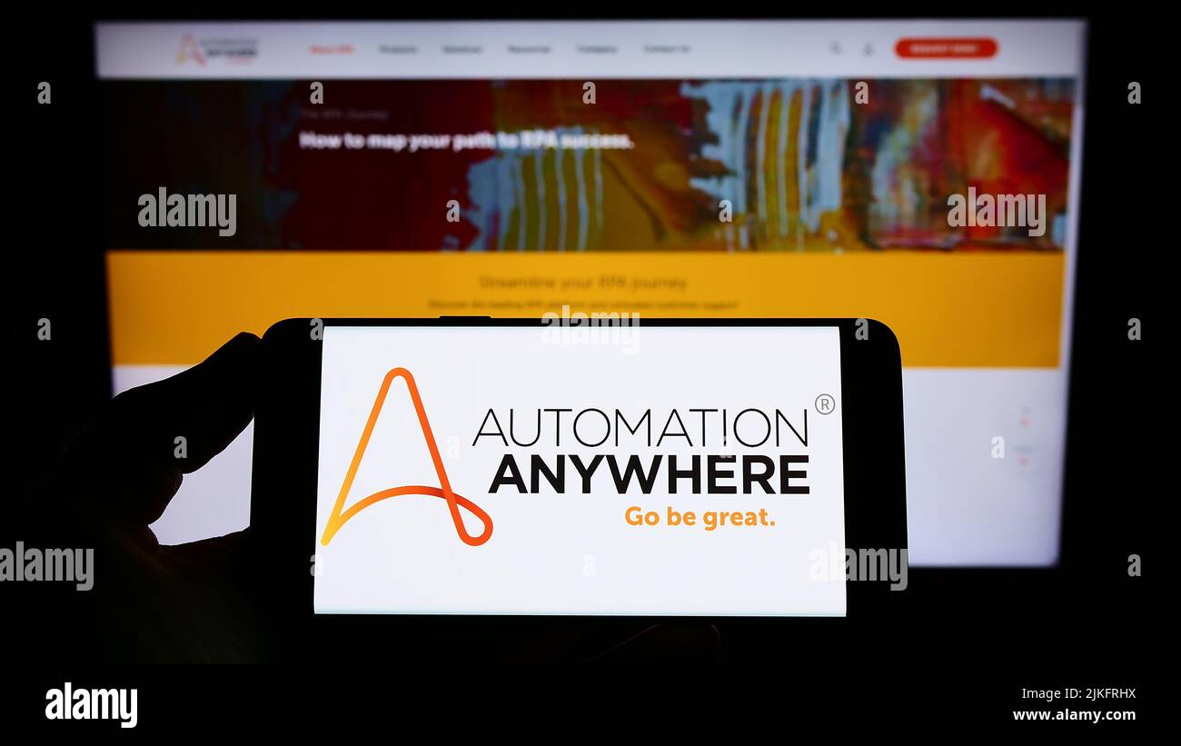 Person holding smartphone with logo of US software company Automation Anywhere Inc. on screen in front of website. Focus on phone display. Stock Photo