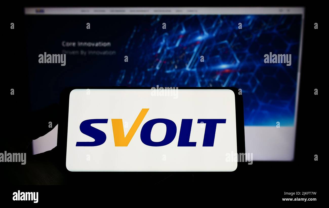 Person holding mobile phone with logo of Chinese company SVOLT Energy Technology Co. Ltd. on screen in front of web page. Focus on phone display. Stock Photo
