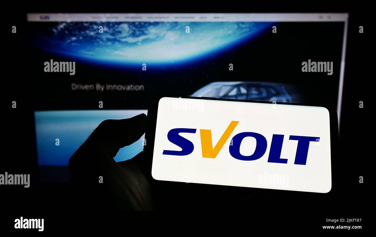Person holding cellphone with logo of Chinese company SVOLT Energy Technology Co. Ltd. on screen in front of webpage. Focus on phone display. Stock Photo