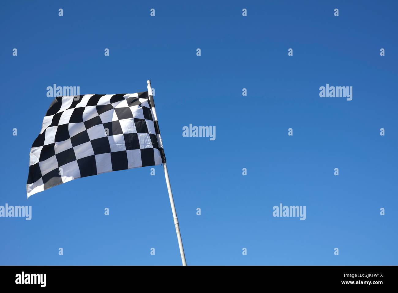 chequered flag against blue sky Stock Photo