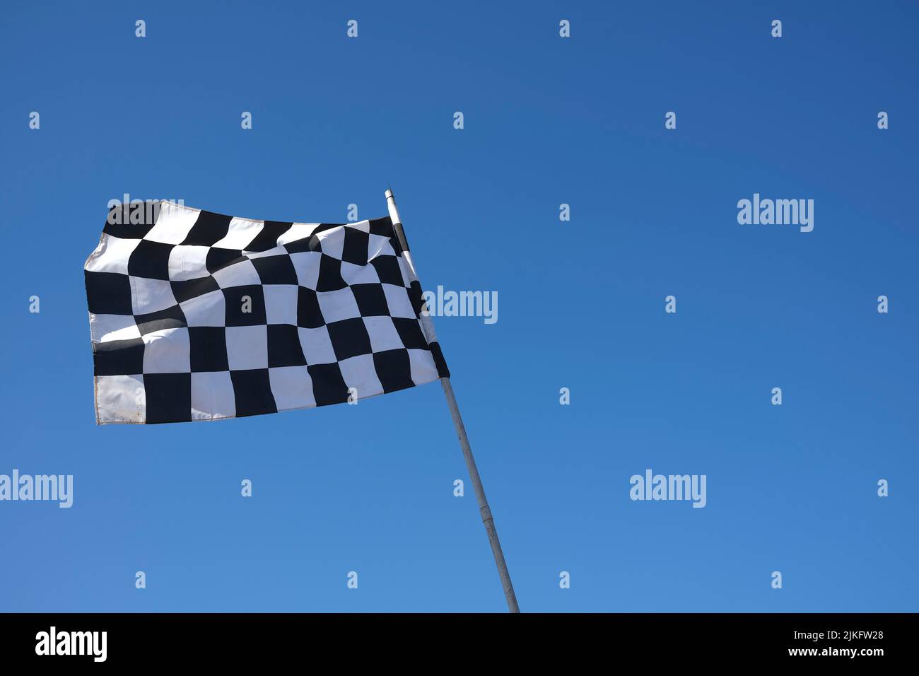 chequered flag against blue sky Stock Photo