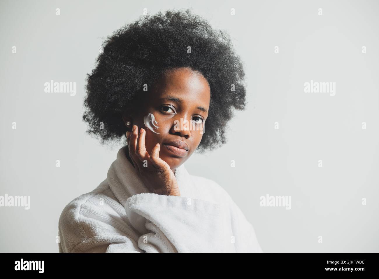 Portrait of a woman with a dab of cream on her face Stock Photo