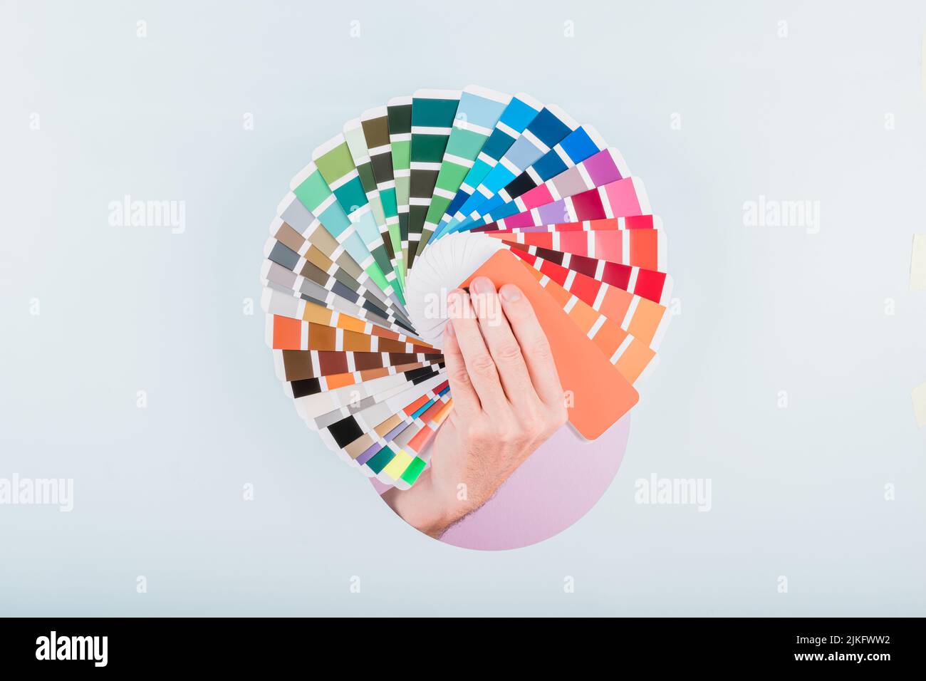 man hand holding a color guide palette on a blue background Stock Photo