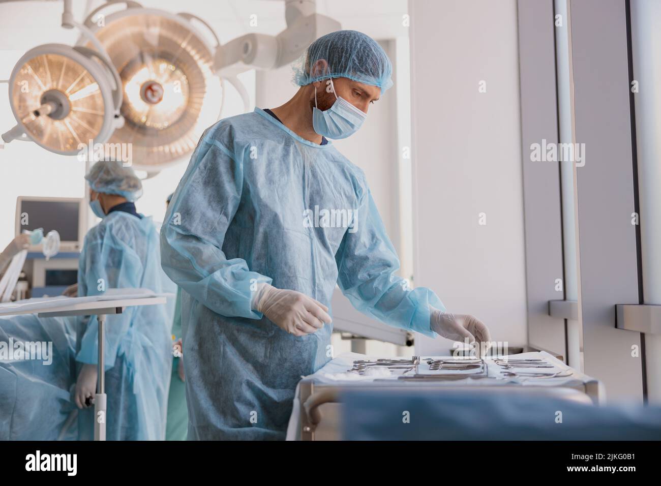 Professional doctor surgeon takes scalpel before surgery in operation room at the hospital Stock Photo