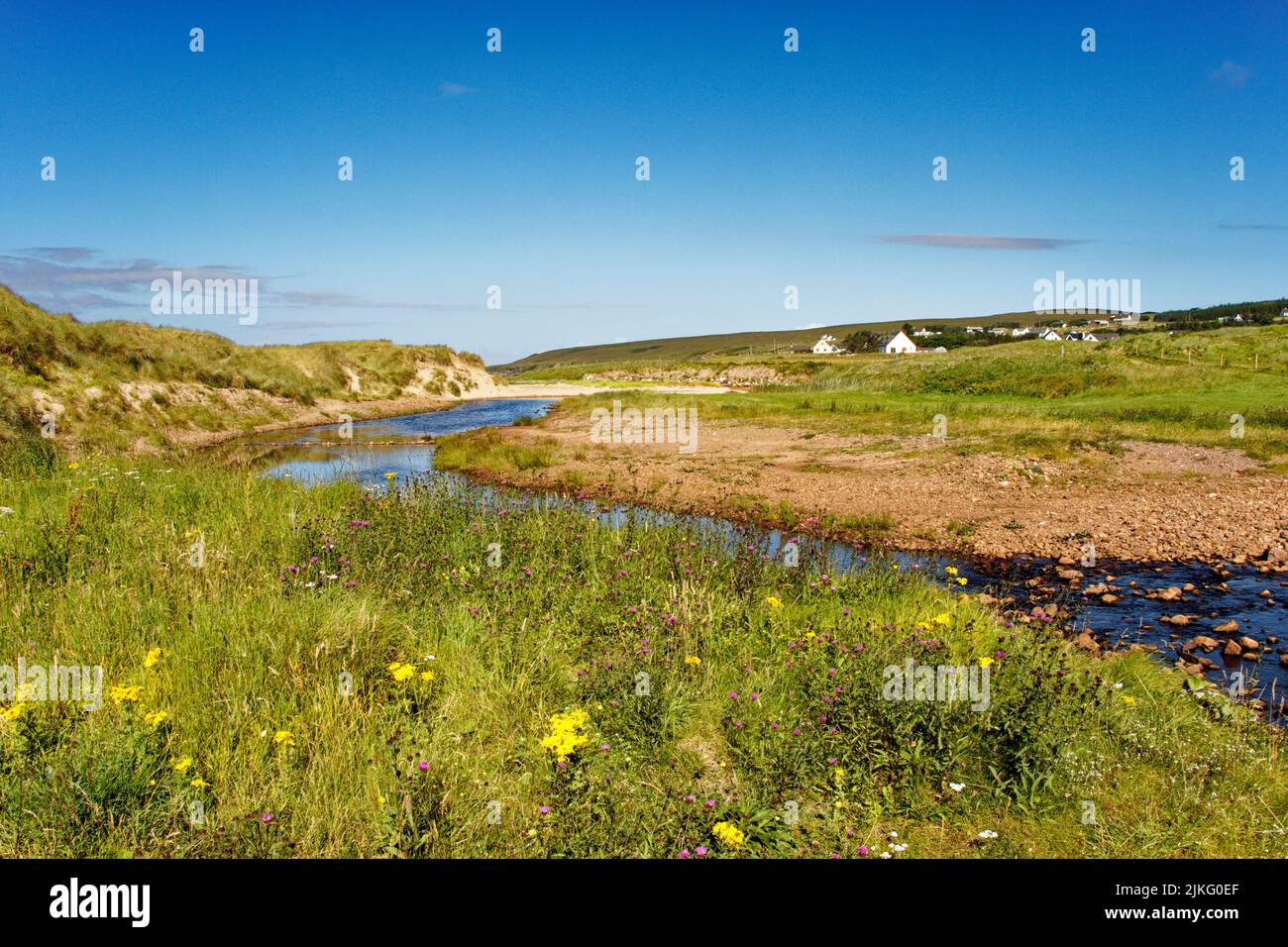 BIG SAND BEACH GAIRLOCH SCOTLAND THE RIVER SAND FLOWING PAST FLOWER COVERED DUNES NEAR THE BEACH Stock Photo