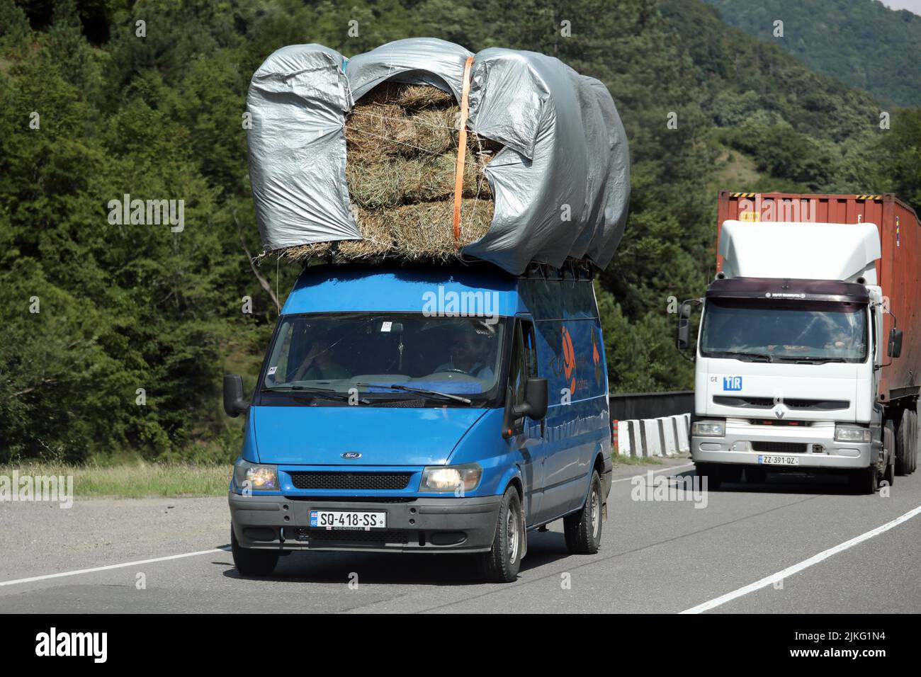 19.07.2018, Georgia, Adjaria, Batumi - Hay bales being transported on the roof of a van. 00S180719D030CAROEX.JPG [MODEL RELEASE: NO, PROPERTY RELEASE: Stock Photo