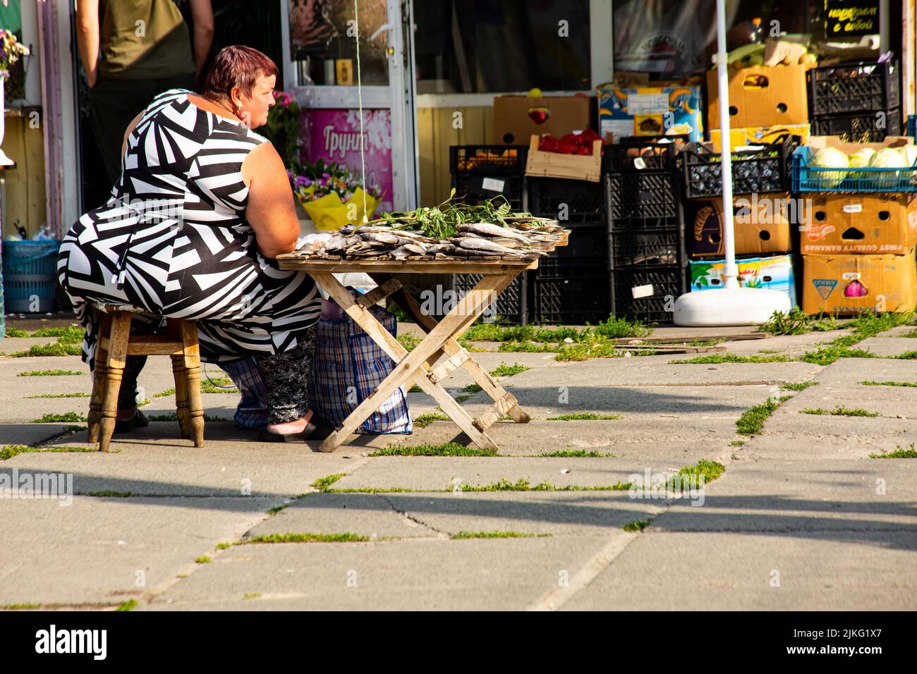 Large-bodied woman is selling on a hot summer day dried freshwater fish on the street in Kiev, Ukrainedesire Stock Photo