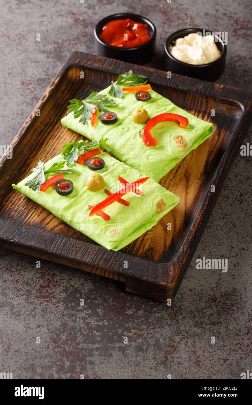 https://c8.alamy.com/comp/2JKG2J2/funny-kids-burrito-monster-with-sauces-on-a-wooden-tray-on-the-table-halloween-food-vertical-2JKG2J2.jpg