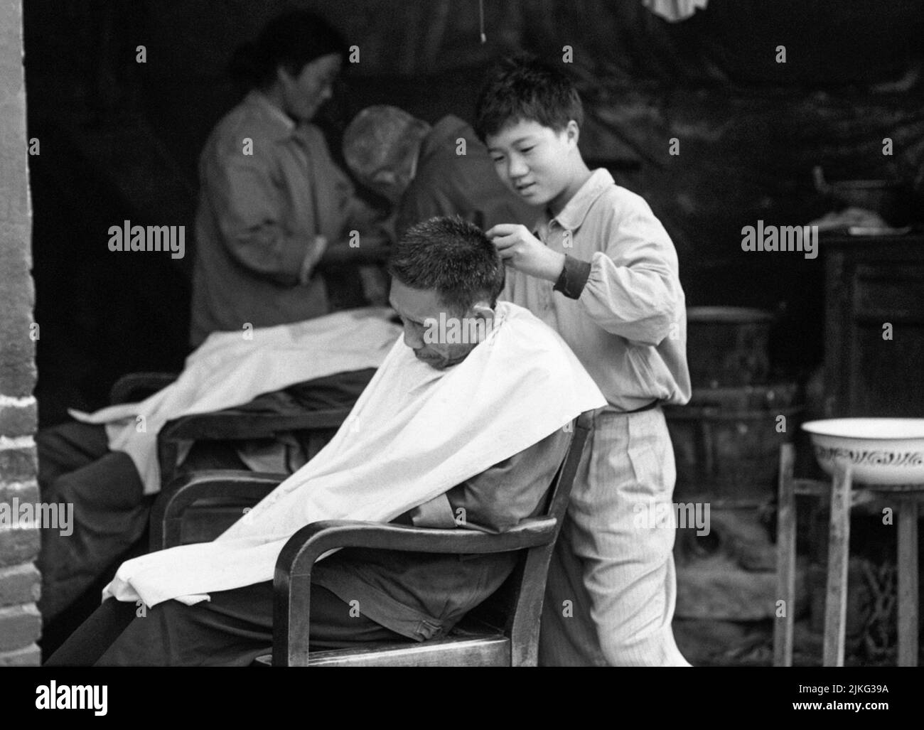 CHINA XIAN Hairdresser cuts customer´s hair Stock Photo