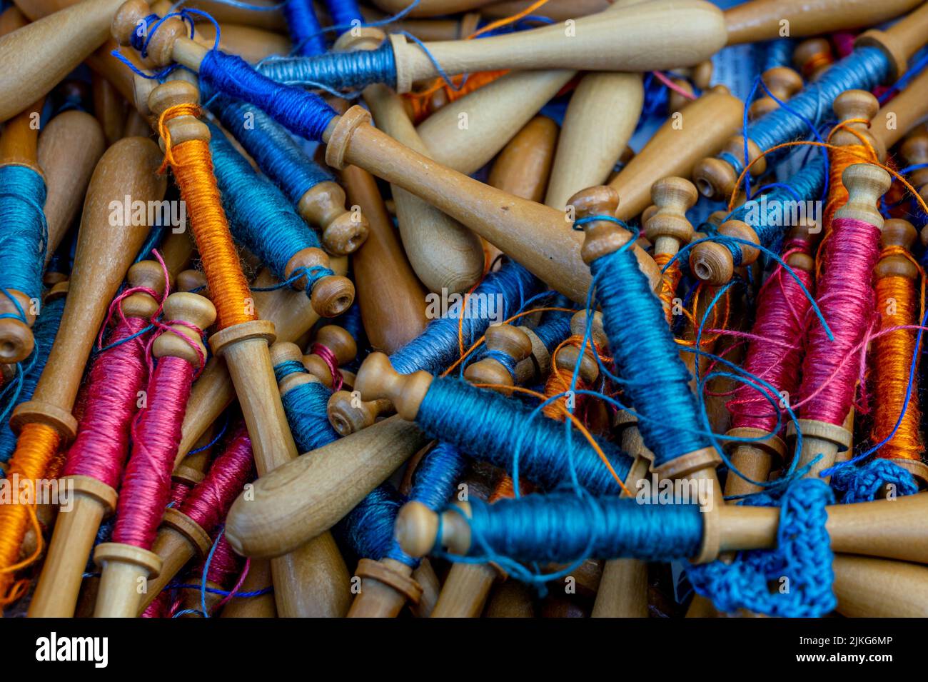 Bobbin lace. Blue, orange and purple lace threads. Close up of colorful