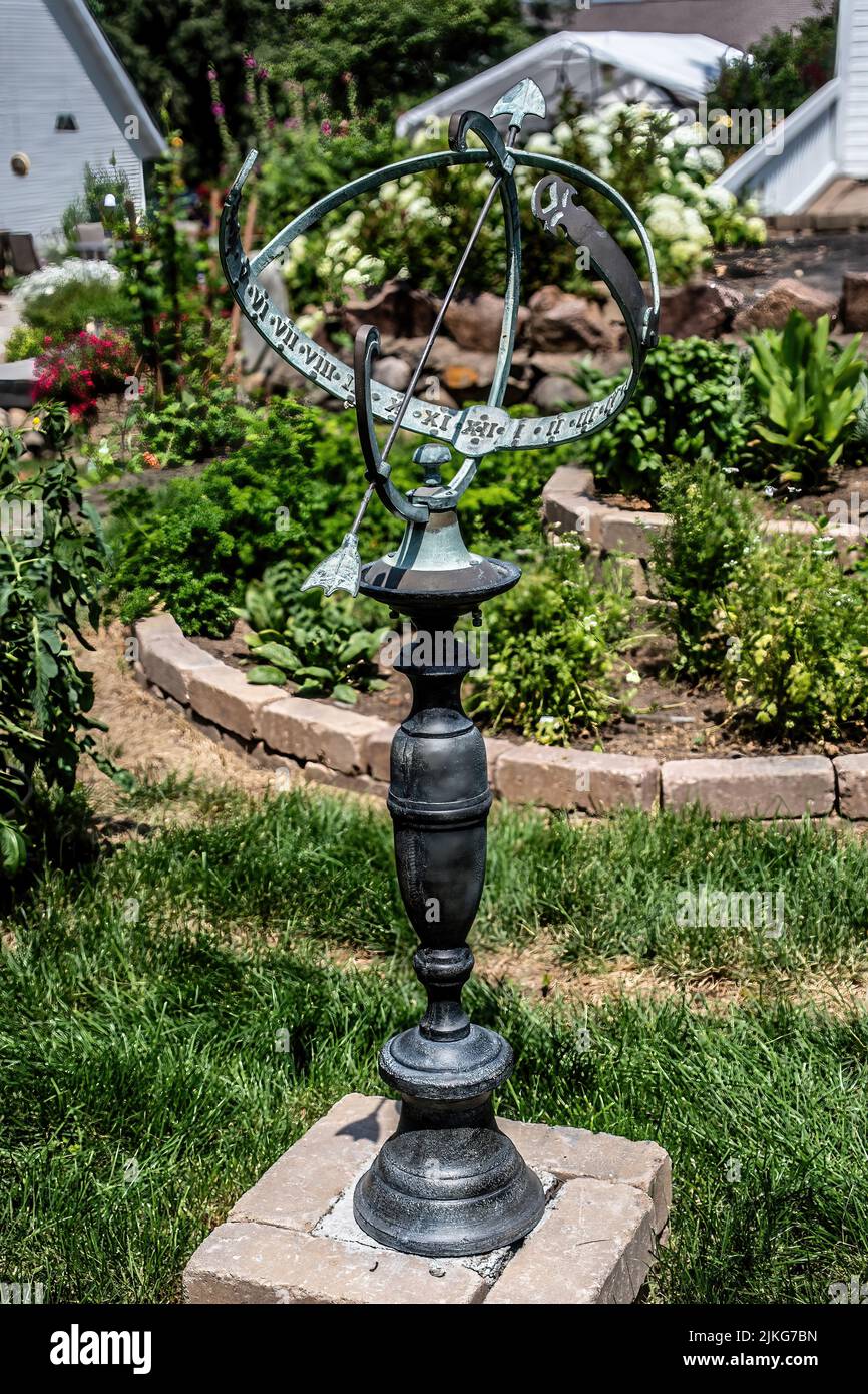 Sundial in use in a summer garden. The Romans adopted the Greek sundial in 293BC. Stock Photo