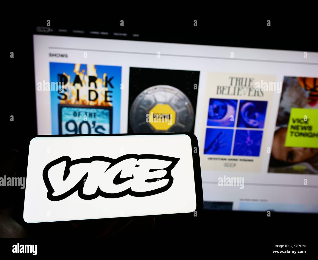 Person holding cellphone with logo of broadcasting company Vice Media LLC on screen in front of business webpage. Focus on phone display. Stock Photo