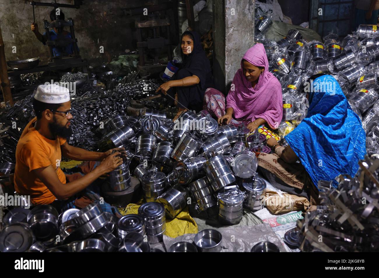 Workers package tiffin carriers inside a factory in Dhaka, Bangladesh, August 2, 2022. REUTERS/Mohammad Ponir Hossain Stock Photo
