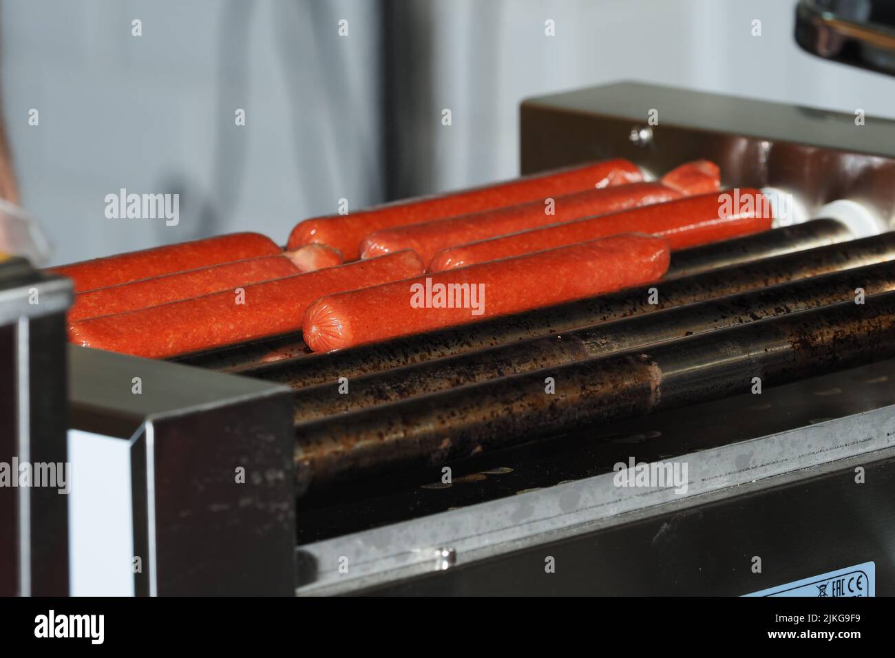 Sausages for hot dogs on a spit, sausages on the grill. Stock Photo