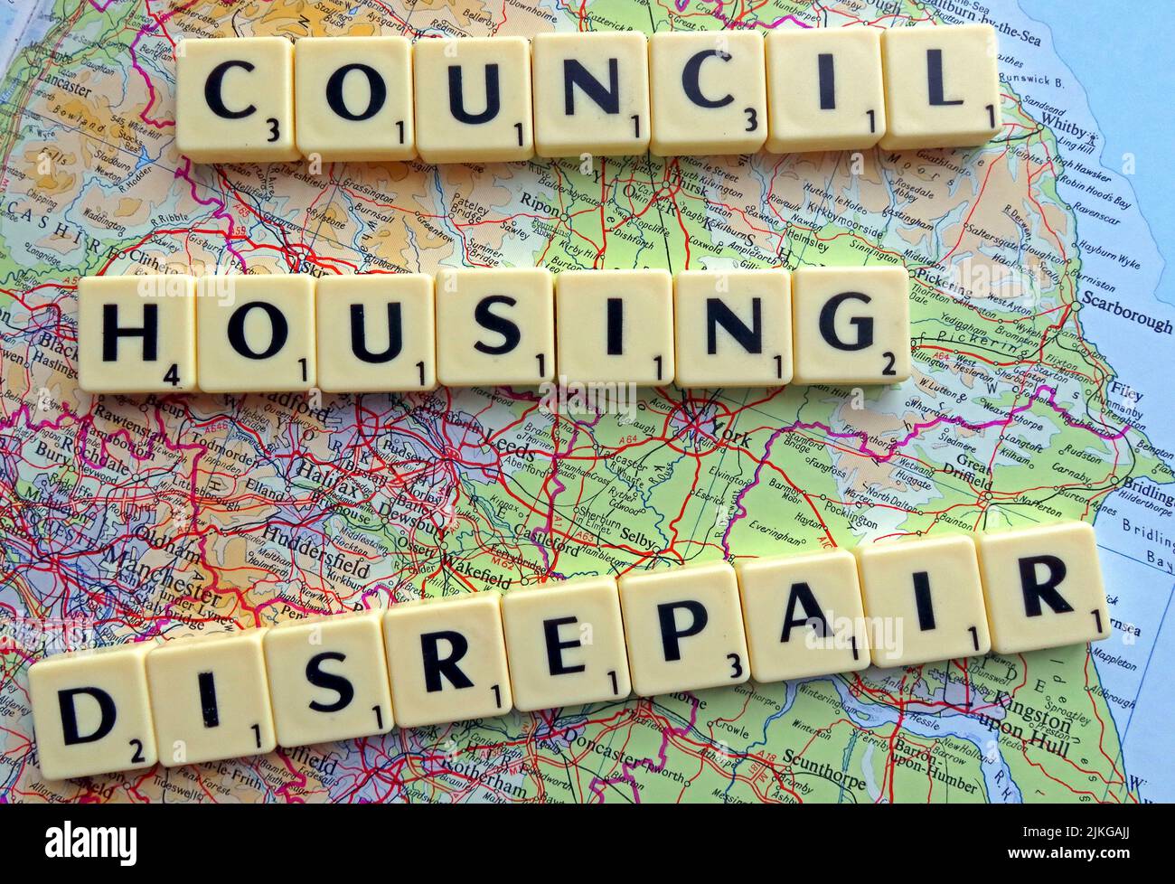 SocialHousing / Council Housing Disrepair problems with responsive repairs spelled out in Scrabble letters on a map of northern England & Midlands Stock Photo