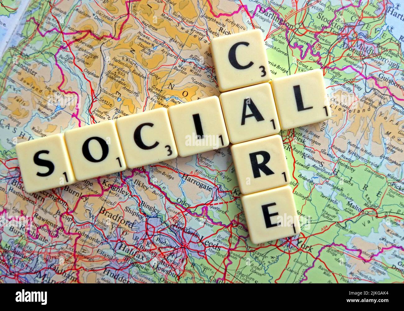 Social Care spelled out in Scrabble letters on a map of England Stock Photo