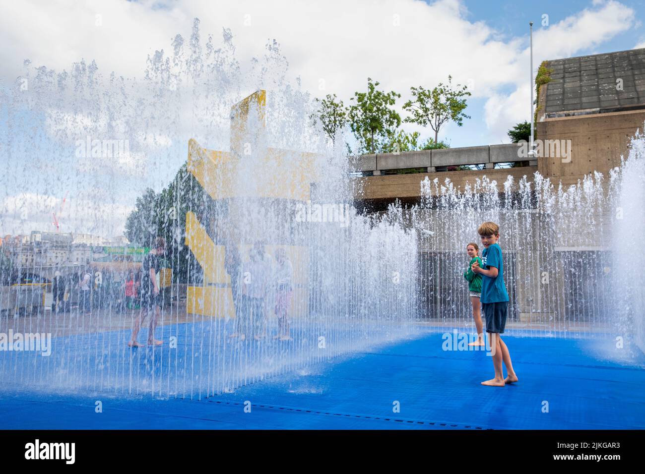 Children play i a water feature at the Southbank Centre, London, UK. Stock Photo