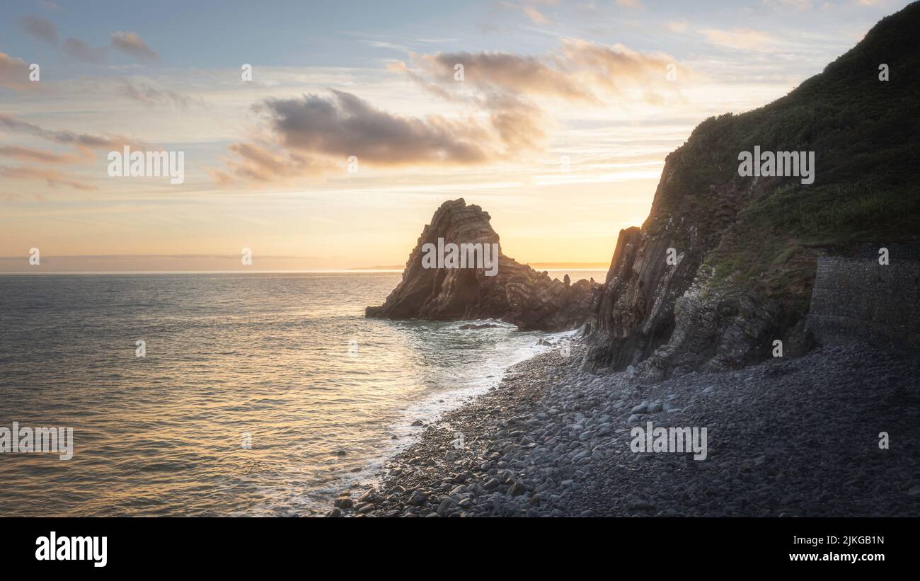 Sunrise over rocky coastline. Black Church rock in Devon, UK.Beautiful seascape scene with golden morning light over rocky beach. Stock Photo