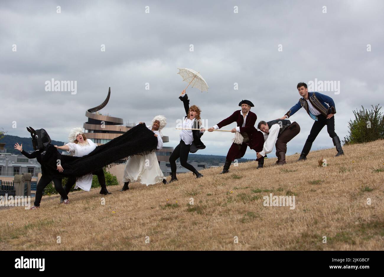 Edinburgh. Scotland. UK. 2nd August 2022. Photocall: Literary closing and slapstick on Calton Hill. The Fringe the six actors from the brilliantly fast paced slapstick romp Classic! (daily 3- 29 August Pleasance 1) will wear a smorgasbord of 17th, 18th, and 19th century costumes (think wigs, parasols, long velvet, military jackets and jolly jack tars). With props including trumpets, parasols, a pantomime horse, very unperiod water pistols and a bright pink melodica). They will be clowning and posing with the city behind them and on The National Monument of Scotland. Pic: Pako Mera/Alamy Li Stock Photo