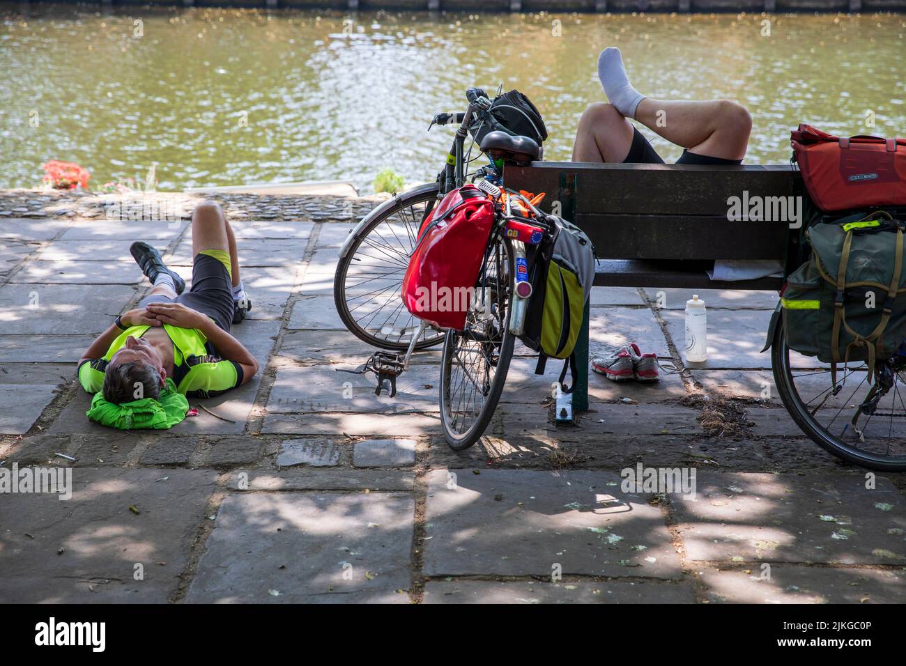 Cyclist resting in the shade alongside the River Ouse, York, UK.  Summer Heatwave in York. A new UK record temperature, of 40.3C was set during the day in Lincolnshire . York,  2022, UK. Stock Photo