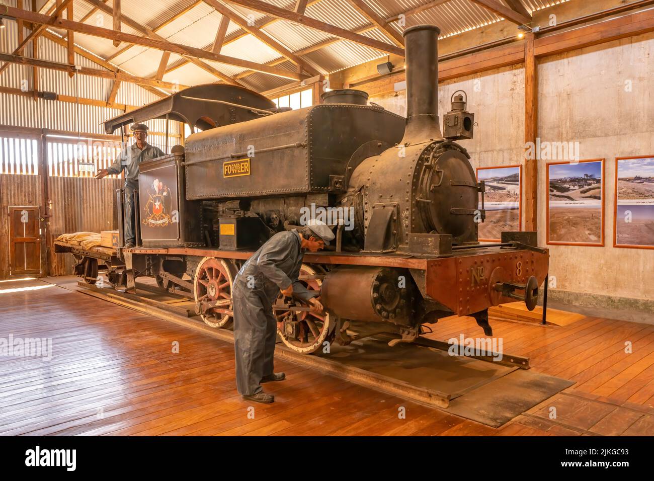 A steam engine with mannequins on display in the museum of the saltpeter or nitrate processing plant at Humberstone, Chile. Stock Photo