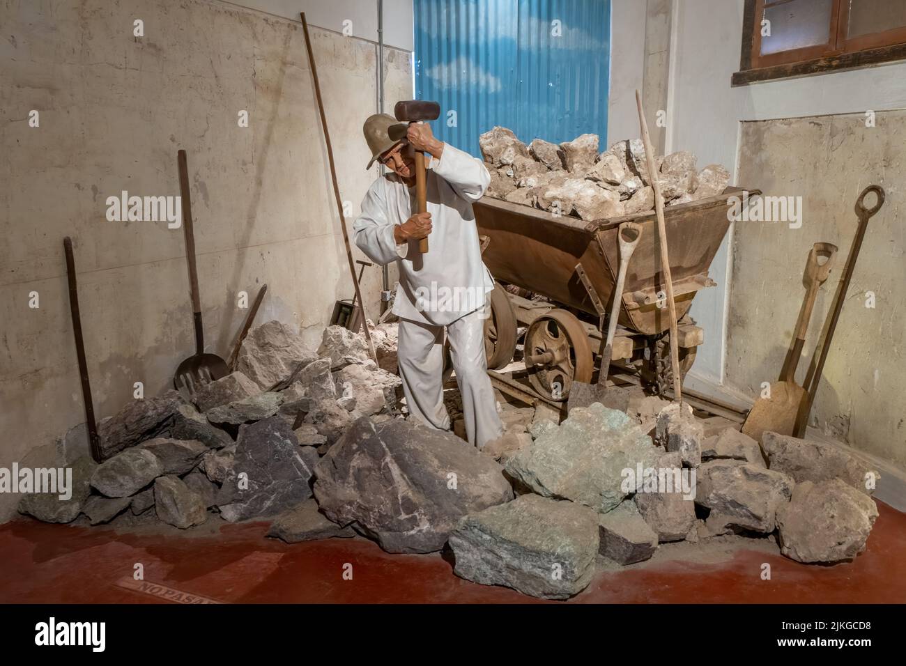 Display with a mannequin showing a laborer breaking up caliche rock for transport in the museum at Humberstone, Chile. Stock Photo
