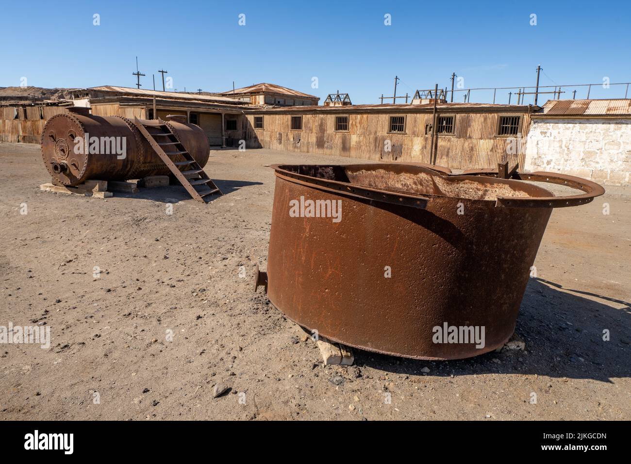 Old rusted vats and a steam boiler in the outdoor museum of the saltpeter works at Humberstone, Chile. Stock Photo