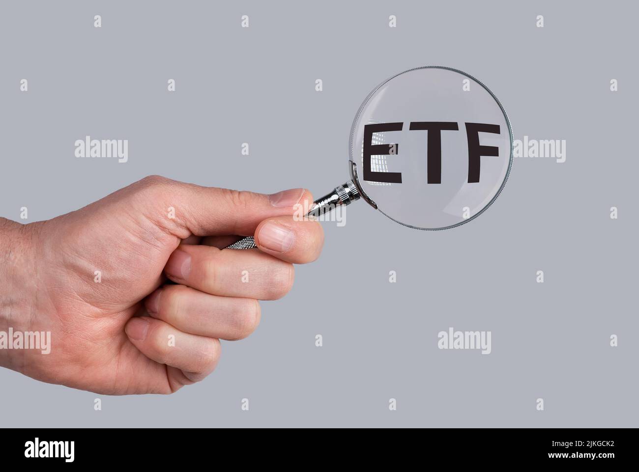 ETF acronym through magnifying glass in male hand. Stock Photo