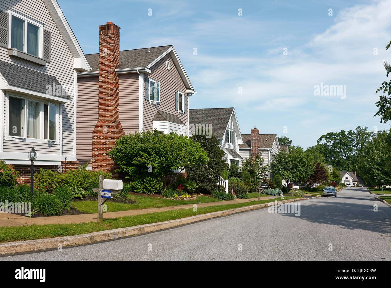 suburban street, sidewalk, single houses, landscaping, mailboxes, trees, shrubs, grass, attractive, summer Stock Photo