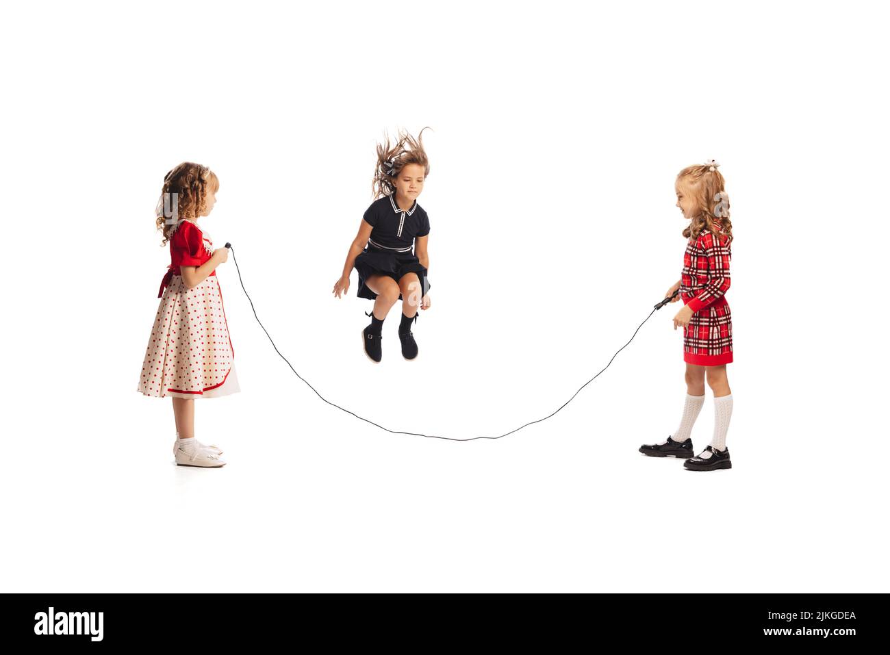 Portrait of little girls, children playing together, jumping over a ...