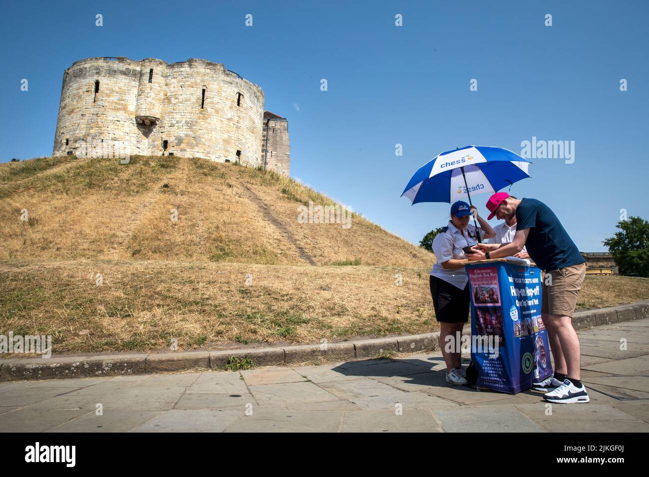 A tour operater taking shelter from the sun near Castlegate, York.  Summer Heatwave in York. A new UK record temperature, of 40.3C was set during the day in Lincolnshire . York,  2022, UK. Stock Photo