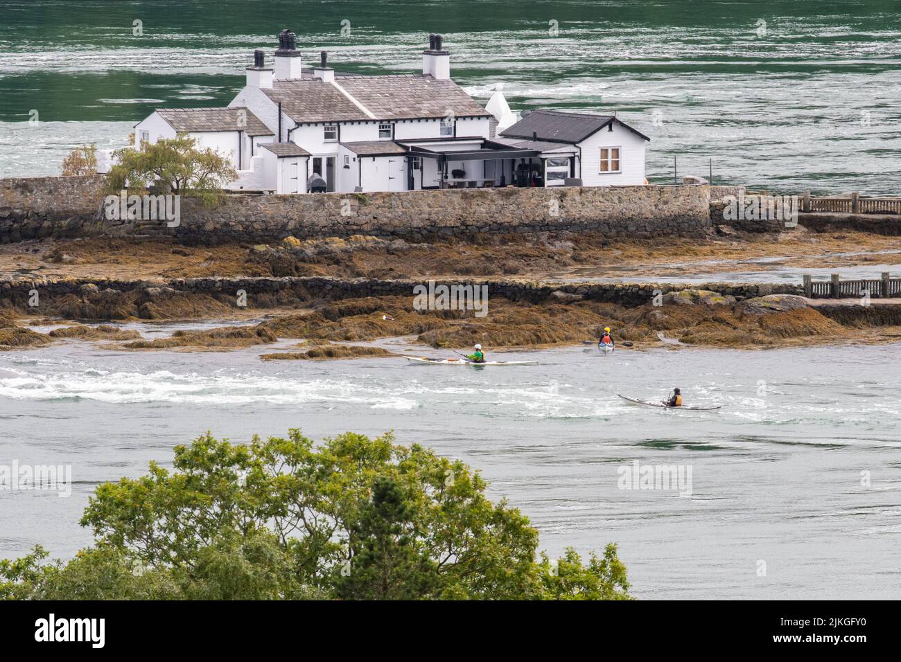 kayakers paddling the currents and whirlpools of the Swellies next to Red Weir Island, Menai Strait,  North Wales Stock Photo