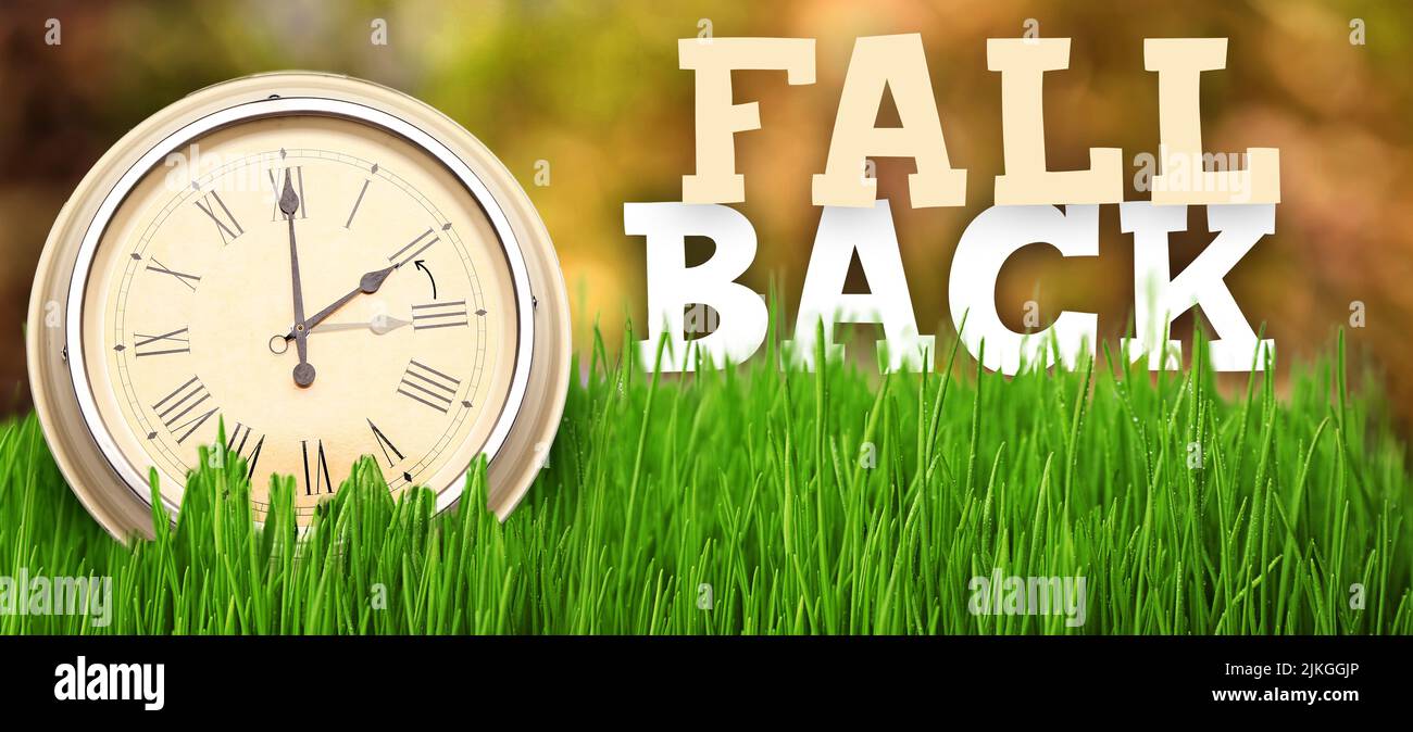 Clock on grass outdoors. Fall back concept Stock Photo Alamy